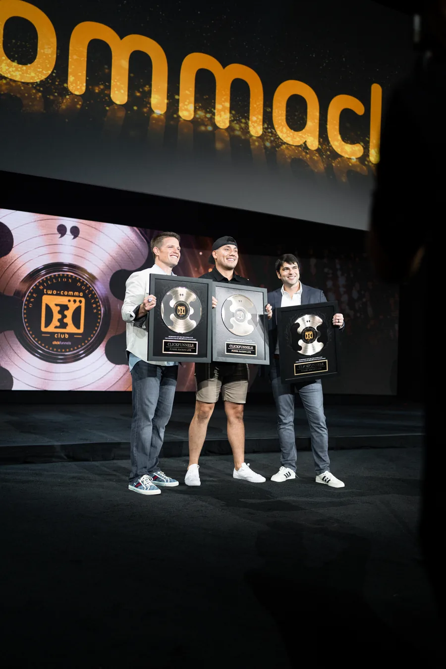 Paul Alex on stage with award plaques